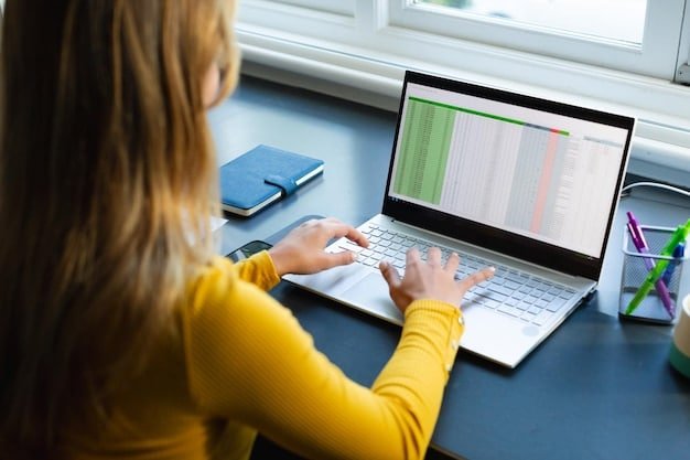 A person sitting at a desk reviewing a spreadsheet on their laptop with subscription services listed, representing an organized assessment of subscriptions.