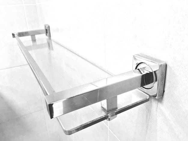 A bathroom with grab bars installed near the toilet and in the shower. The grab bars are silver and contrast with the white tiles. A shower chair is placed inside the shower.