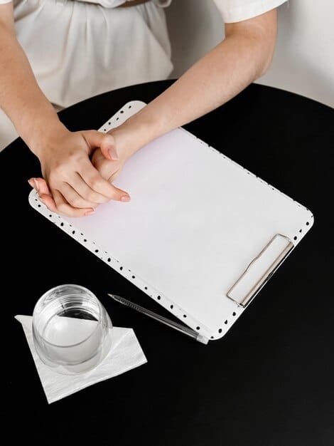 A person is shown carefully filling out IRS Form 8936 on a desk, with a pen in hand and supporting documents organized nearby. The setting is a well-lit home office.