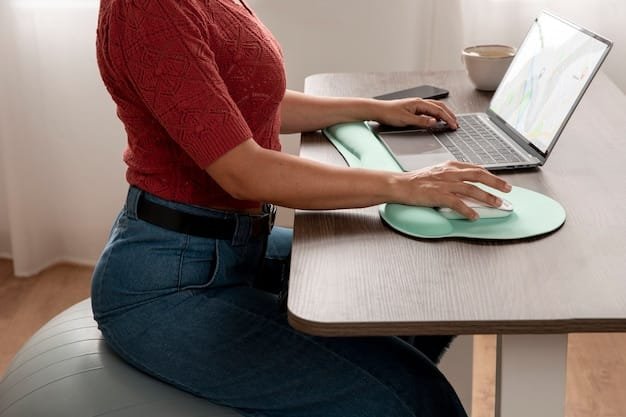 A person sitting at a desk, working on a laptop with an external monitor. The setup includes ergonomic accessories like a wrist rest and an adjustable laptop stand, highlighting the importance of comfort and posture for remote workers.