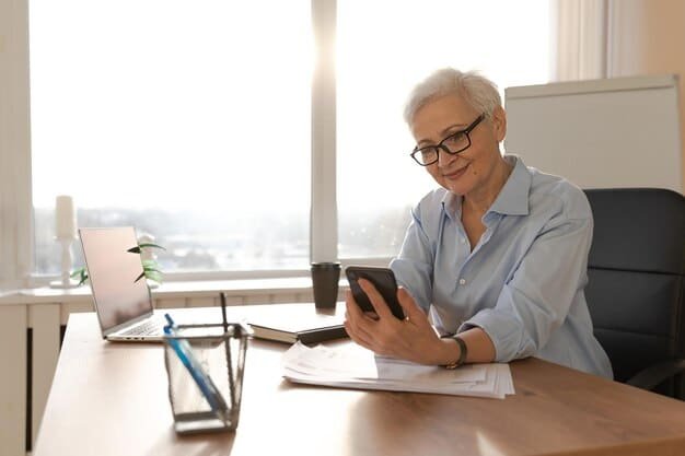 A person confidently negotiating medical bills over the phone, with a calculator and notepad on their desk. The person is smiling, indicating a successful negotiation.