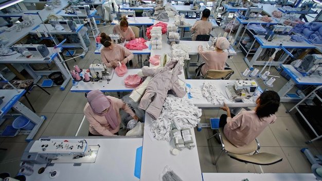 A brightly lit garment factory with adequately spaced workstations and proper ventilation, showcasing safe and ethical working conditions for apparel workers.