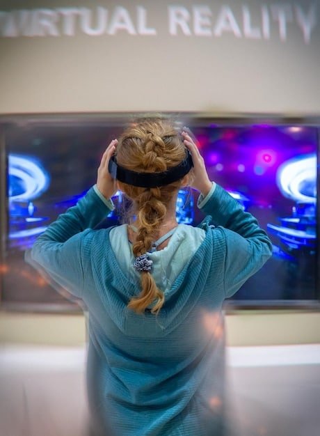 A split screen showing a gamer wearing the Valve Index headset with base stations visible in the background, and another gamer using the Meta Quest 3 in a living room setting. Both gamers appear fully engrossed in their VR experiences.